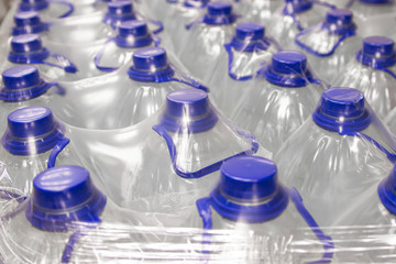 Water in plastic bottles packed with plastic wrap.