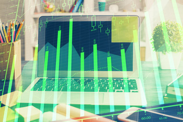 Financial graph colorful drawing and table with computer on background. Double exposure. Concept of international markets.