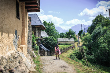 A girl walking through a village in the mountains