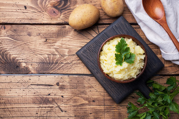 Homemade cream mashed potatoes in a dish with parsley. copy space