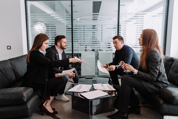 a company of business people at a business meeting in the office discussing a new contract