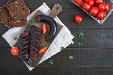 Morsilla - blood sausage. Pieces of Spanish black pudding on a wooden cutting board. Easter menu....