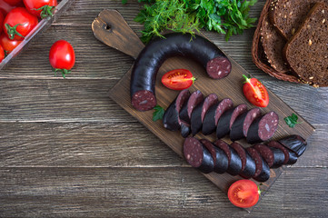 Morsilla - blood sausage. Pieces of Spanish black pudding on a wooden cutting board. Easter menu....