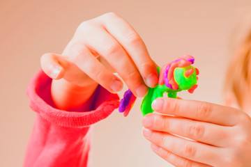Сute little girl learns to make plasticine statues.