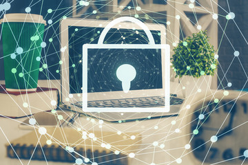 Double exposure of desktop with computer and lock icon hologram. Concept of data safety.
