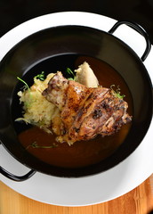 Baked shank and mashed potatoes on a plate closeup