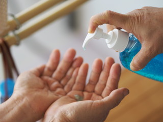 woman's hand is pressing the bottle of the alcohol gel pump give to another hand, for cleaning dirty to prevent germs protect colona virus, covid 19