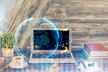 Double exposure of desktop with computer and world map hologram. International data network concept.