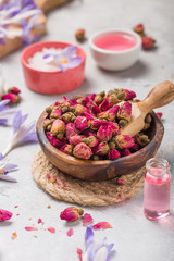 Spa and wellness concept with  dry roses, pink oil and creame on concrete  background.