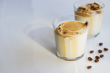 South Korean coffee dalgona – trendy cold latte or cappuccino with milk and cane sugar. Summer drink for breakfast