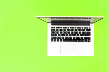 Fototapeta na wymiar Open laptop on light green background. top view. place for text. online education concept or remote work at home