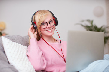 Girl student happy to communicate with friends headphones via Internet