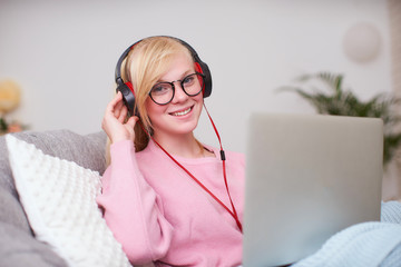 Naklejka premium Girl student happy to communicate with friends headphones via Internet