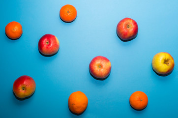 Fruit background. Apples and mandarins are drawn in smooth lines on a blue background