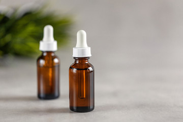 Two brown dropper bottles on a gray background. Beauty concept. Natural oils.