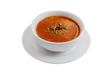 Tomato soup or gazpacho in a white bowl on white background