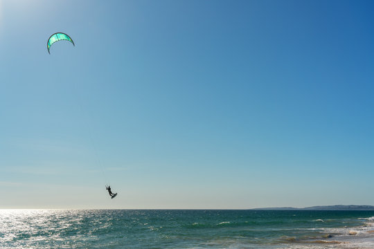 The athlete practices kate board surfing the sea on the waves. Summer in Portugal Algarve.