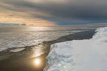 Sun shining on icy sea, Greenland.