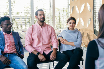 Startup team interviewing job candidate. Young men and women in casual sitting in training room, listening to female speaker. Interview concept