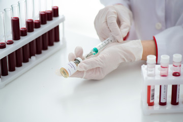 Test tubes with blood sample Covid-19 coronavirus. Vaccine and syringe injection It use for...