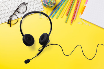 Office yellow backdrop with supplies and headset