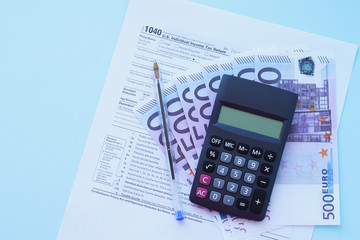 a tax return in the United States 1040 "Tax Return". Selective focus. A calculator, a Declaration form with euros and a pen for filling out the tax form.