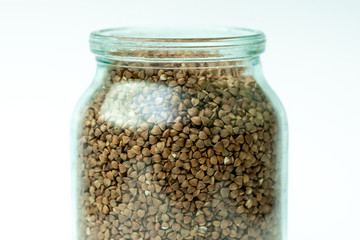 buckwheat in a bank on a white background. place for text. raw cereal grains