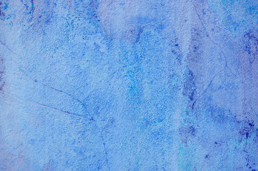 Blue background. Wall covered with old cracked stucco, tinted in classic blue. Bright neon backdrop. Modern urban industrial concept. Copy space. Selective focus image.