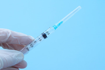 Fototapeta premium A hand in a medical glove holds a syringe. Selective focus. Vaccination