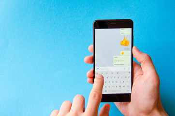 A male hand holds a smartphone, points a finger, types. Communication on a smartphone,...