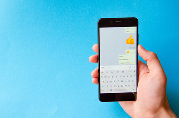 A male hand holds a smartphone, points a finger, types. Communication on a smartphone,...