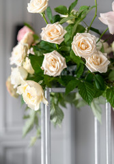 Bouquet of white roses with raspberry leaves on the table. Dressing at a wedding.