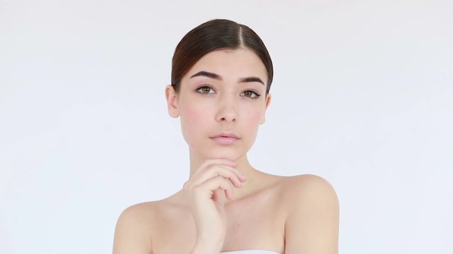 Slow motion of woman with beautiful face and perfect skin just cleaned from impurities pampering gently with fingers. Skin treatment concept video, touching skin, skin concept video. 4K , Slow motion