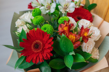 Bunch of colorful flowers decorated in light green paper, top view