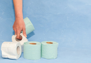 4 rolls of soft toilet paper in hand with space for text. Covid-19 pandemic. Increased potential. High unexpected demand. Deficit.