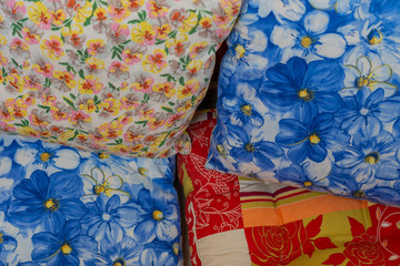 Four colorful pillows laying one upon the other