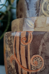 Three glossy clay pots standing one upon the other