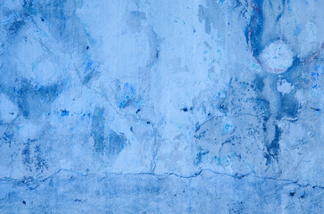 Blue background. Wall covered with old cracked stucco, tinted in classic blue. Bright neon backdrop. Modern urban industrial concept. Copy space. Selective focus image.