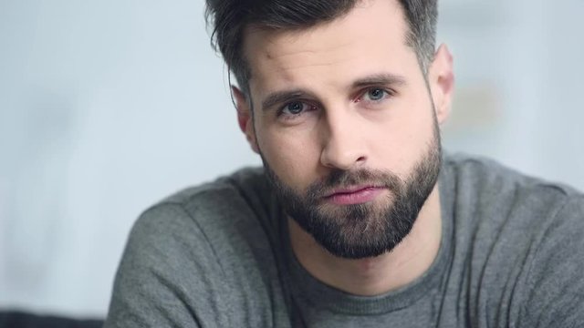 upset and bearded man looking at camera