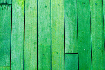 Bright green wooden backdrop, boards. green tinted wood. Fragment of fence, floor or wall of building made of wooden boards, place for text. Copy space.