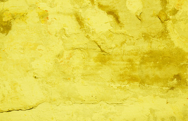 Yellow background. Wall covered with old cracked stucco, tinted yellow. Bright neon backdrop. Modern urban industrial concept. Copy space. Selective focus image.
