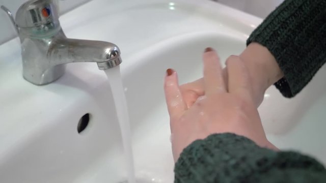 Woman washing hands according to the World Health Organization. Hands are washed with soap to stop coronavirus.