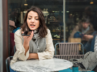 Beautiful girl uses smart phone at a cafe