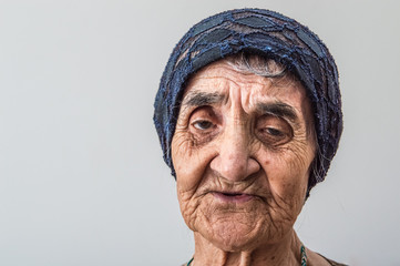 Portrait of an old grandma with a blue bonnet