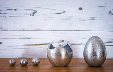 Ostereier und Eierschale in silver vor einem Holz Hintergrund