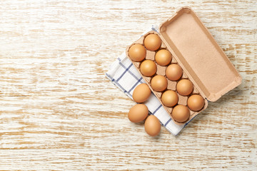 Organic  eggs in carton box on a kitchen table, top view.