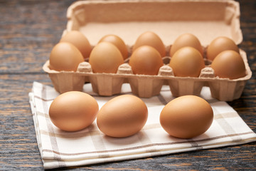 Сhicken eggs in carton box on a kitchen table, selective focus.