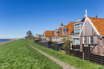 Fototapeta na wymiar Historic houses behind the dike in Frisian village Makkum, Netherlands