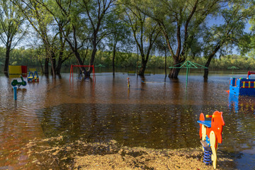 Sunny flooded landscape. Wet children playground.