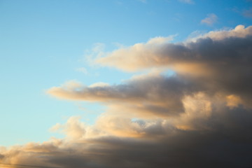 Fototapeta na wymiar Regenwolken bei Sonnenuntergang, Wolken im Schein der unergehenden Sonne